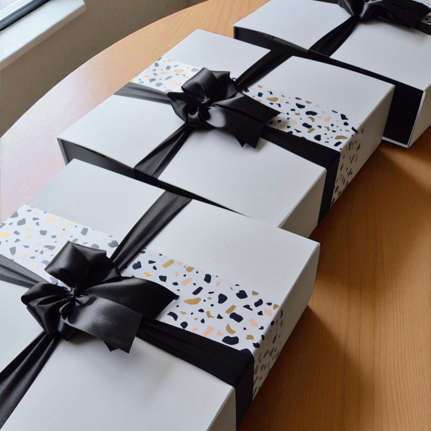 Elegant black-ribbon gift boxes with terrazzo wrap, ready for delivery across Dunedin – beautifully packed by Wickedly Indulgent.