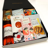 Gluten Free Gift Hamper with wine, honey comb, cookies, bread mix, Chocolate, & gummies. Presented in a modern gift box.