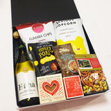 Cheers gift hamper with wine, popcorn, chocolate, fudge, brownie & nuts presented in a beautiful Gift Box.