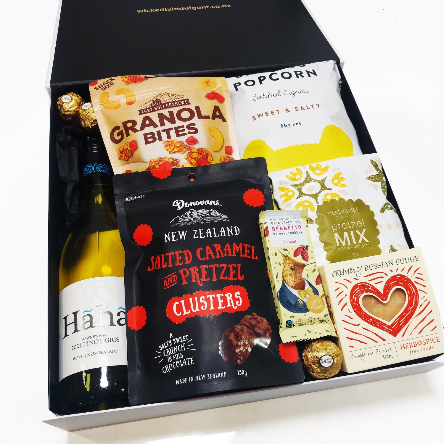 Smiles for miles gift hamper with a bottle of wine and delicious treats presented in a modern gift box.