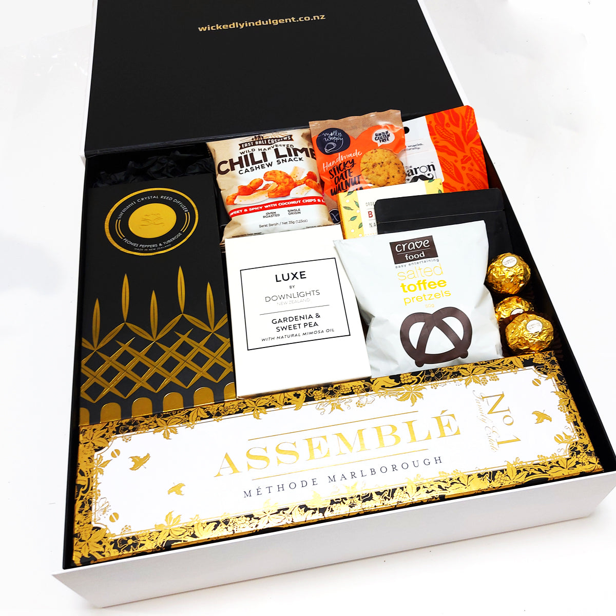 House warming gift box with Champagne, Diffuser, Candle, Chocolate, Nuts, Gingerbread & more. Presented in a modern gift box.