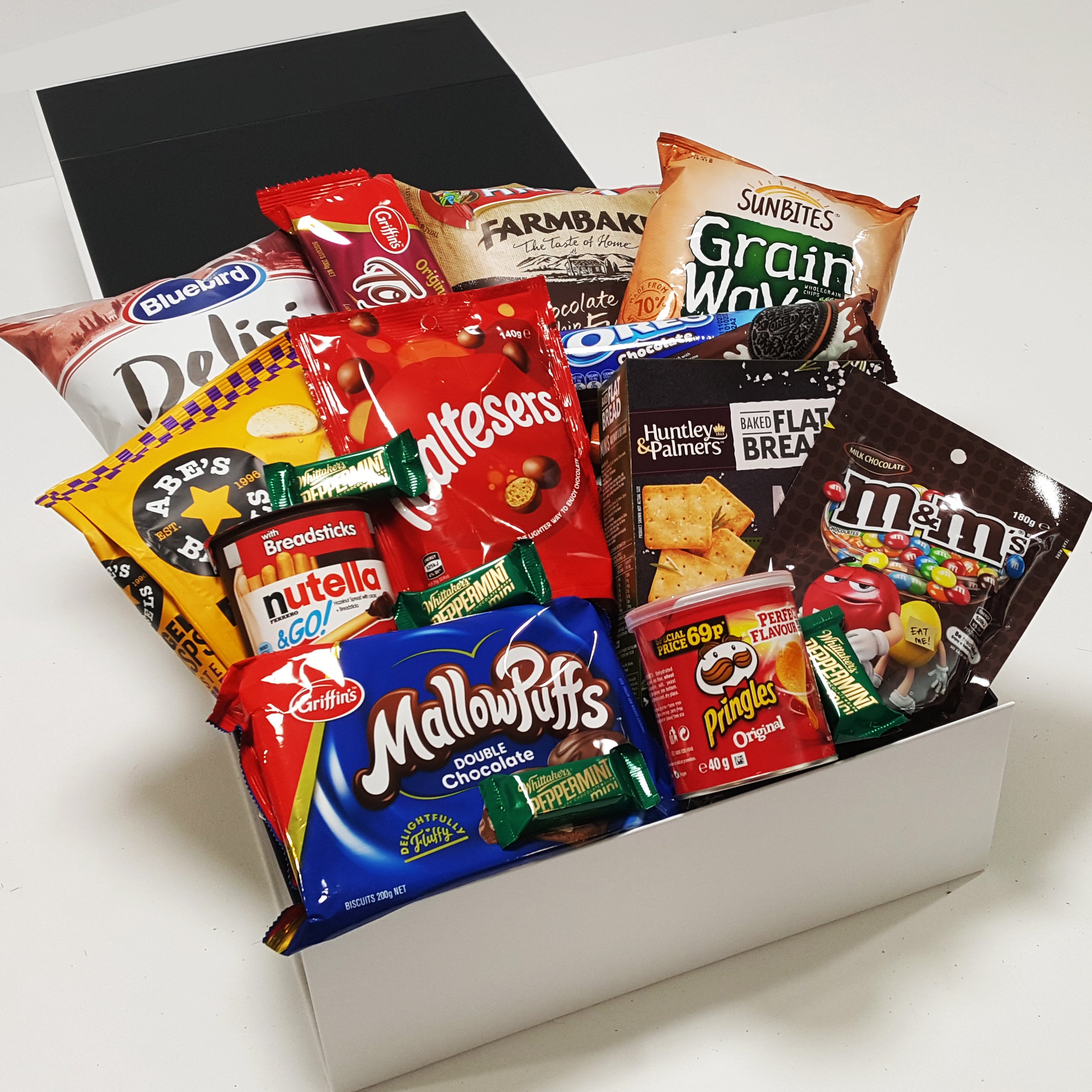 Collection of supermarket gift baskets with mellowpuffs, M&M's, Pringles, Nutella, Whittakers and more all presented in a modern gift box.