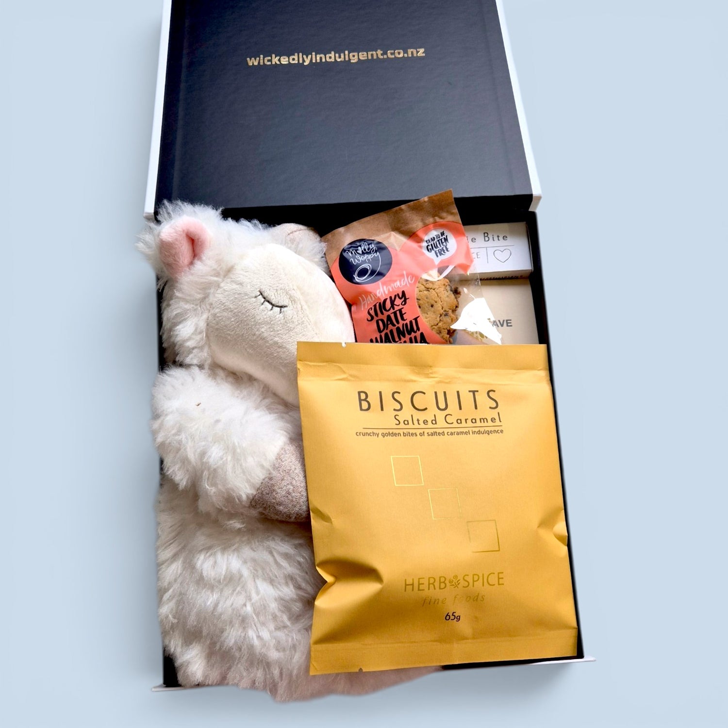New baby gift box with soft billy goat plush, sweet treats, biscuits and parent goodies, beautifully packed in a Wickedly Indulgent gift box.