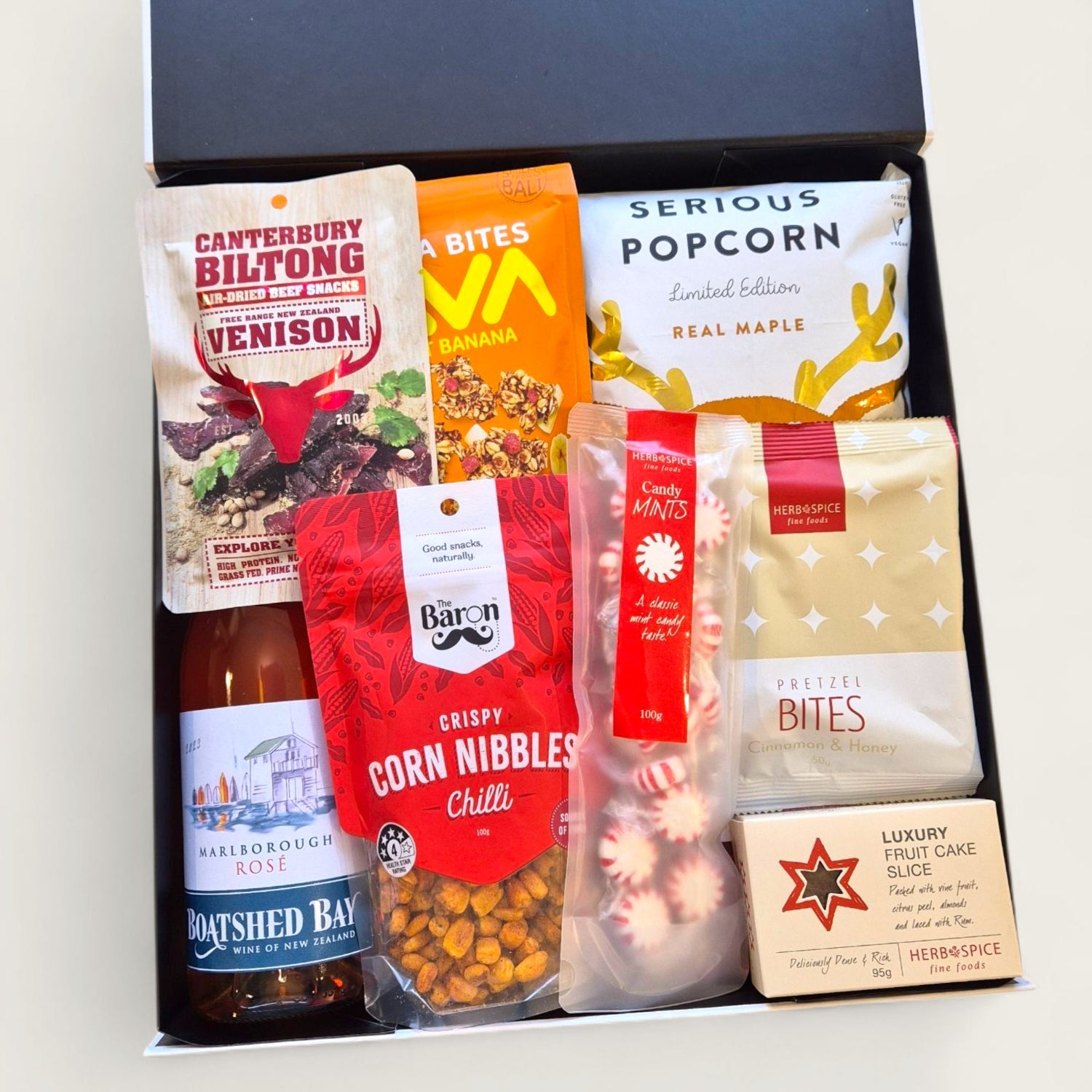 Festive Christmas gift box packed with wine, venison biltong, serious popcorn, luxury shortbread, and holiday snacks worth unwrapping.