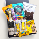 Easter gift hamper with sparkling wine, chocolate bunny, mini eggs, popcorn and sweet treats in a modern gift box