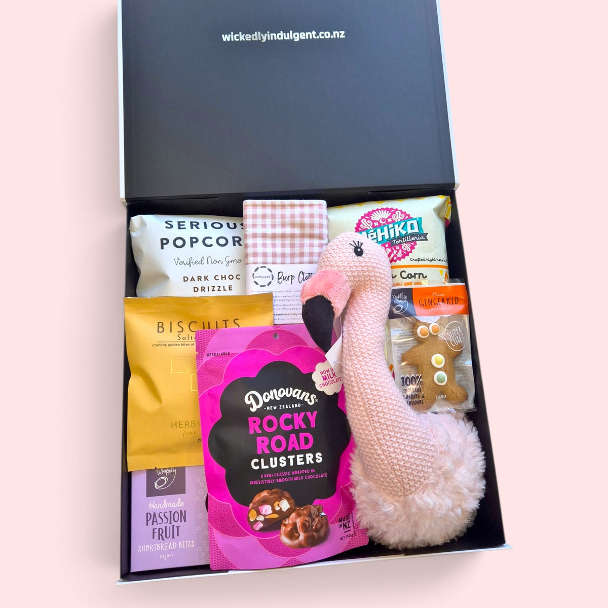 Baby gift box with flamingo nursery wall hanging, burp cloth and treats for new parents.
