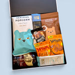 Open black gift box filled with gluten-free dairy-free treats including Buffalo Trace Bourbon popcorn, cashews and chocolate. Wickedly Indulgent NZ gift hamper