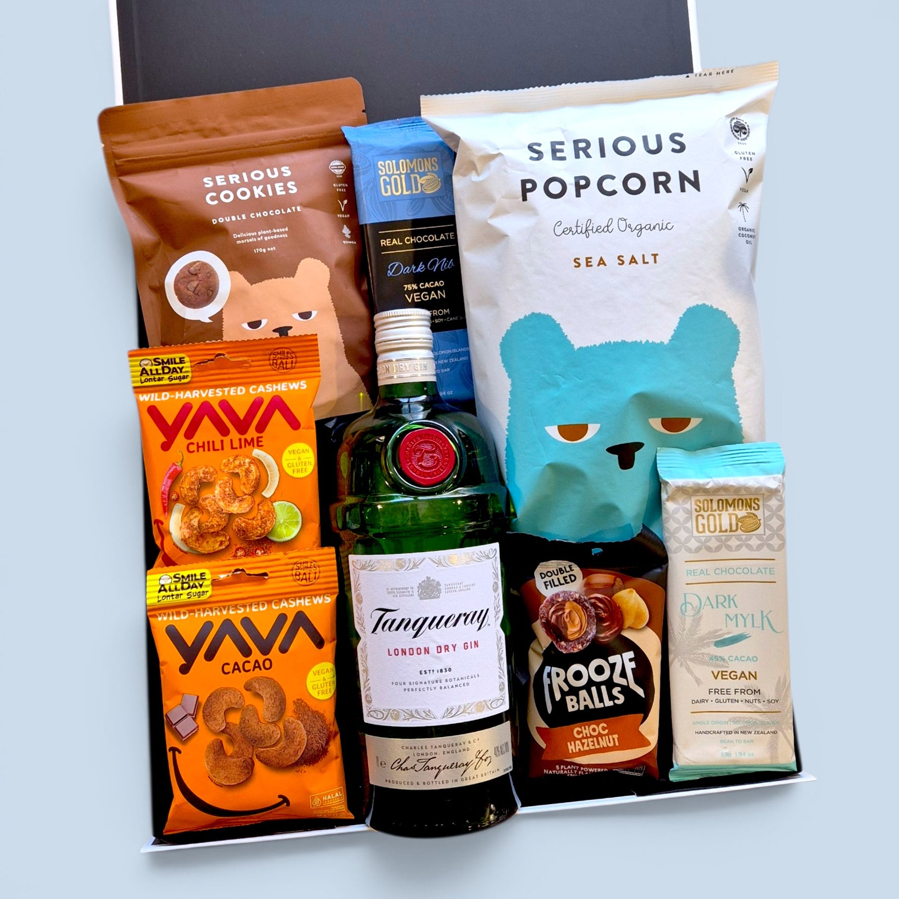 Wickedly Indulgent gluten-free dairy-free booze gift hamper NZ with 
Tanqueray Gin, vegan Solomon's Gold chocolate, Serious Popcorn, 
Serious Cookies and Yava cashews in a black & white gift box