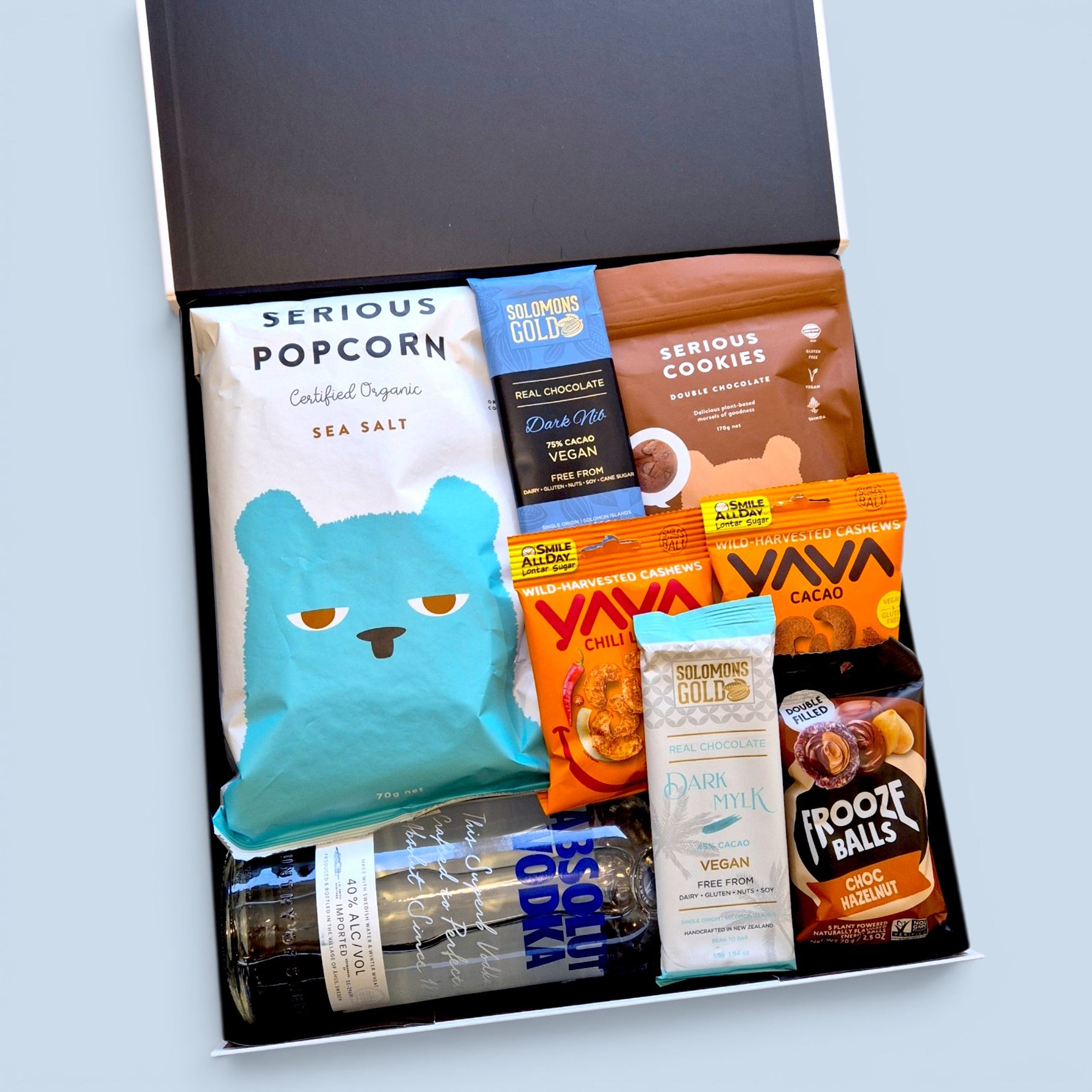 Gluten-free dairy-free gift hamper NZ with Absolut Vodka, Yava cacao 
cashews, Serious Popcorn, Solomon's Gold chocolate, Frooze Balls and 
East Bali cashews — Wickedly Indulgent you choose the booze gift box