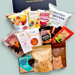Wickedly Indulgent GF Treats on Repeat gluten-free snack gift box NZ 
with Canterbury Biltong, Bennetto chocolate, Solomon's Gold vegan 
chocolate, Serious Popcorn, Serious Cookies and Frooze Balls in a 
black & white gift box
