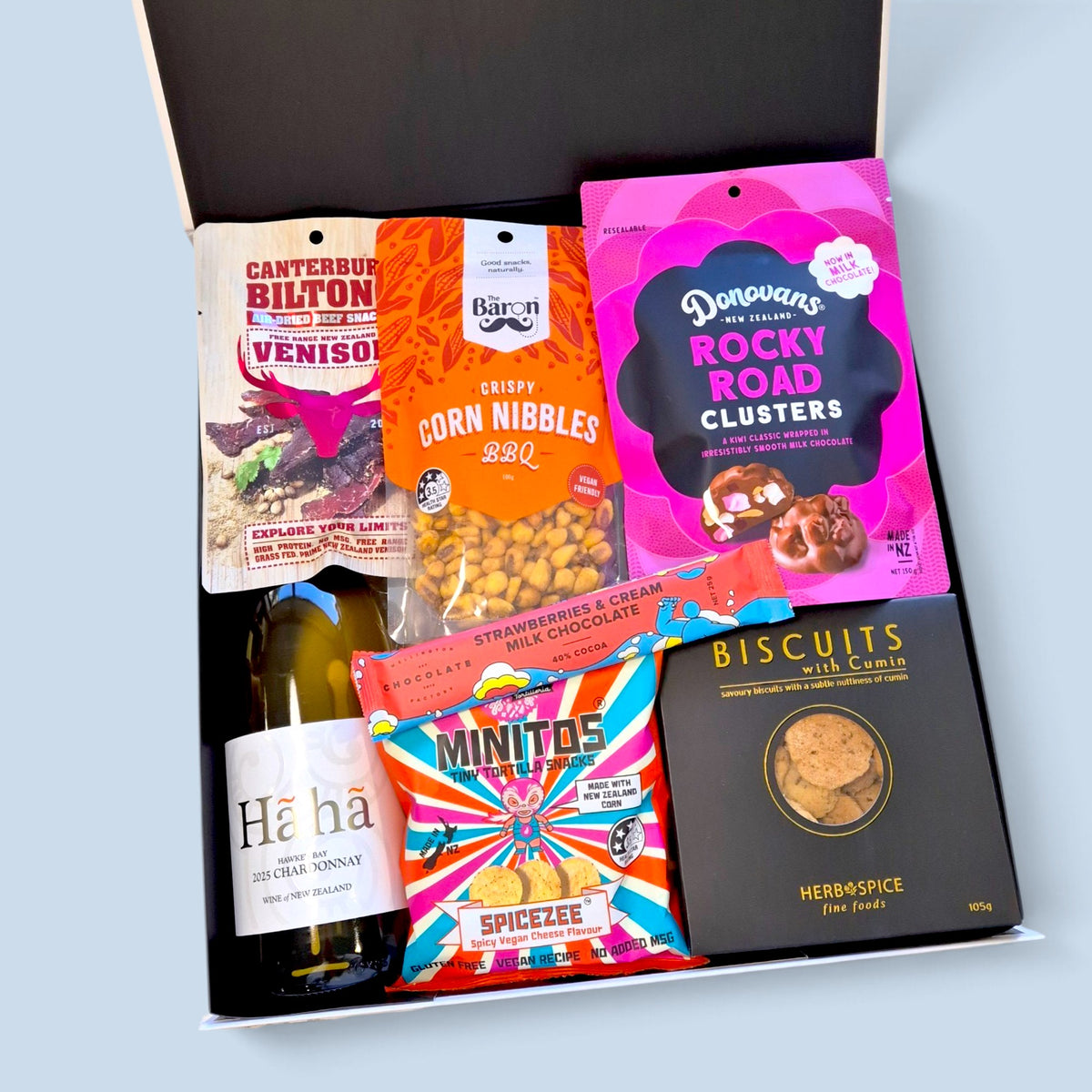 Gift hamper with New Zealand Chardonnay, chocolate treats, biltong, corn nibbles, cumin biscuits, fudge and savoury snacks in a premium gift box.