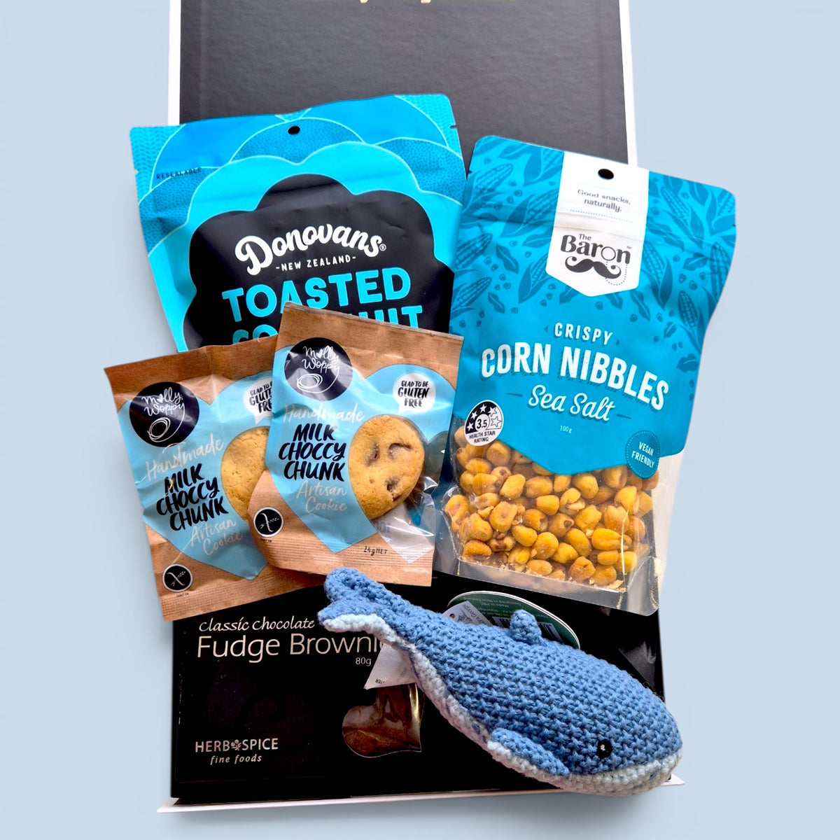 Little Whale Wishes baby gift box featuring a crocheted blue whale rattle, gourmet New Zealand treats and beautifully presented gift box.