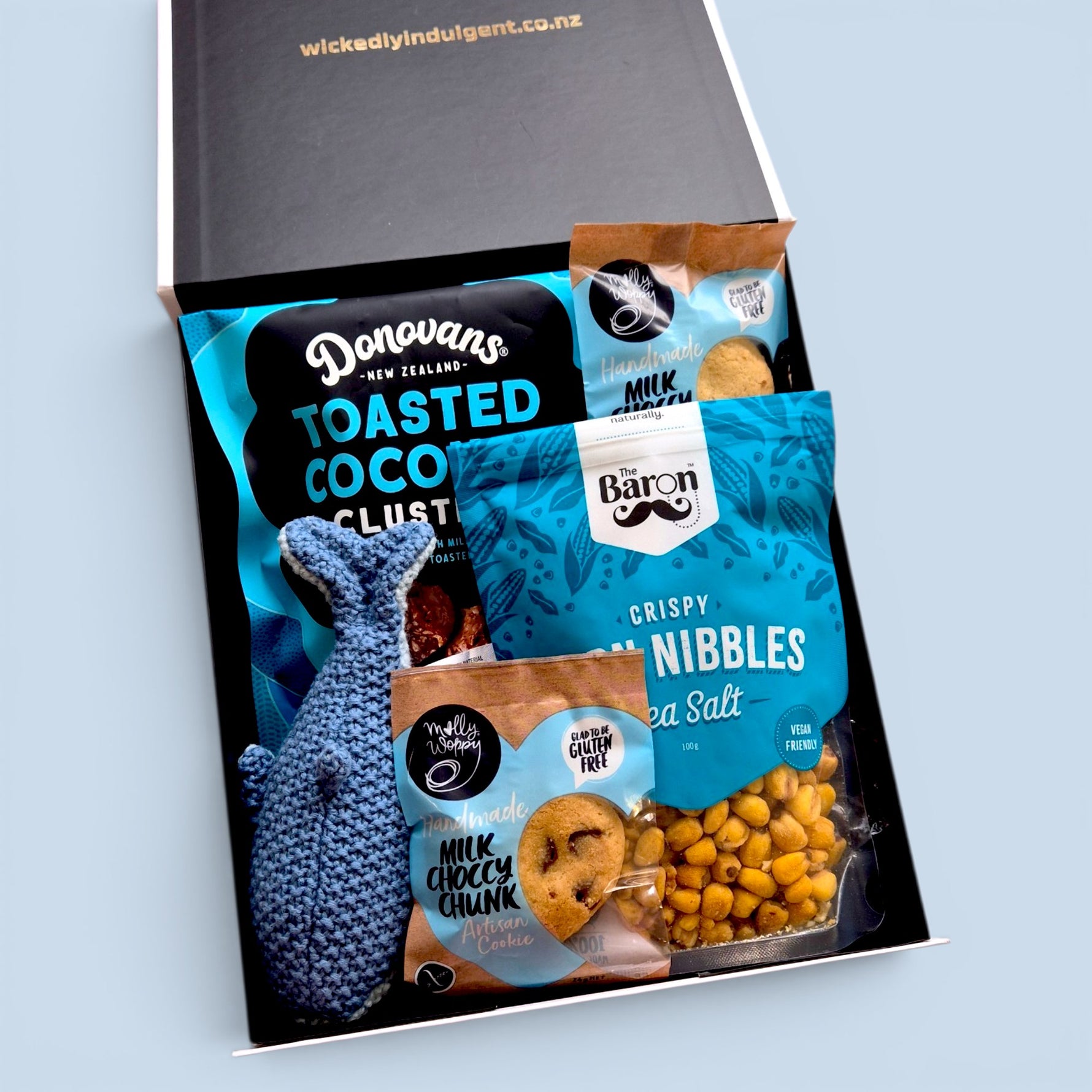 Little Whale Wishes baby gift box featuring a crocheted blue whale rattle, gourmet New Zealand treats and beautifully presented gift box.