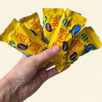 Hand holding five Buzz Bars chocolate bars in gold packaging, perfect Easter gift hamper add-on.