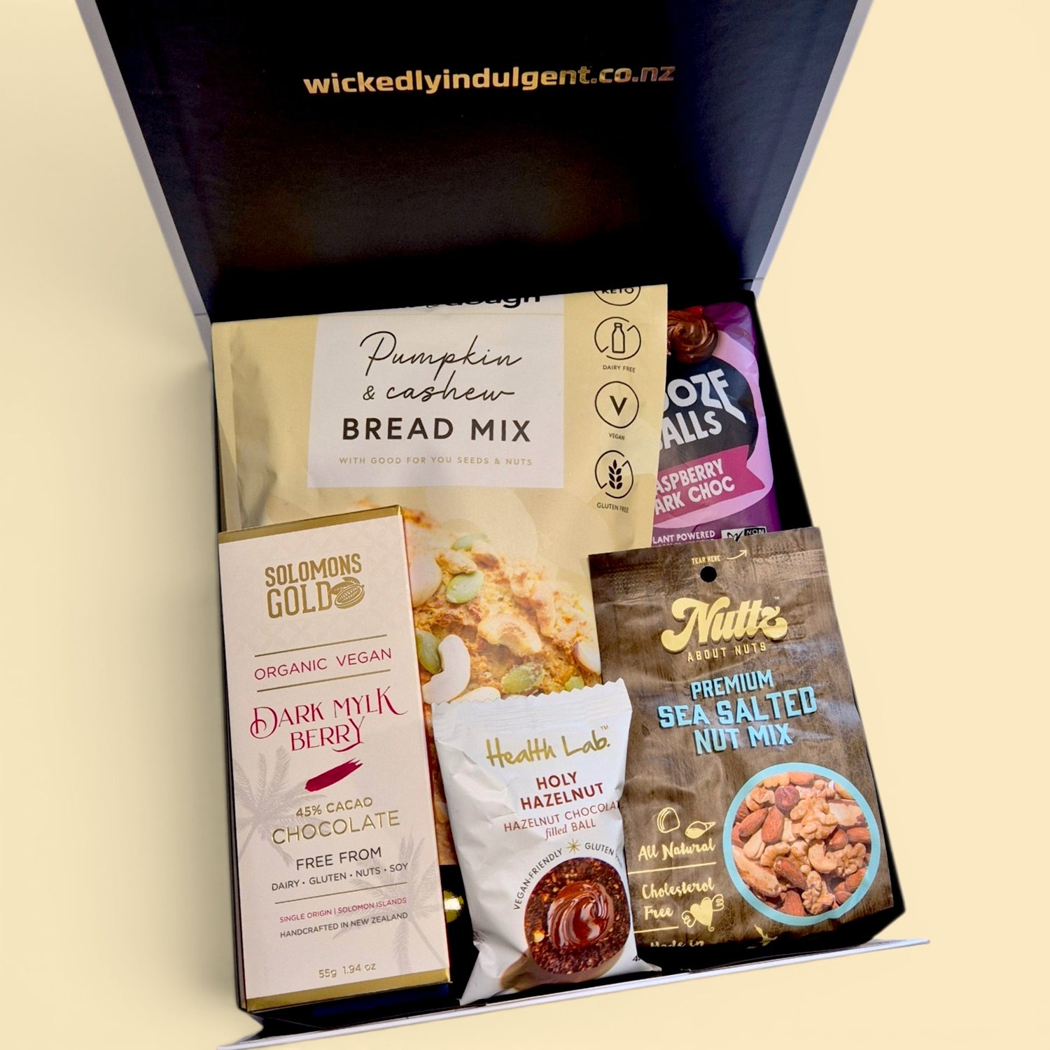 Dairy free gift hamper with wine, bread mix, chocolate, popcorn and snacks presented in a black & white Wickedly Indulgent gift box.