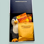Penguin Snuggles baby gift box with soft penguin plush, salted caramel biscuits, fudge brownie, caramel fudge and cashew treats.