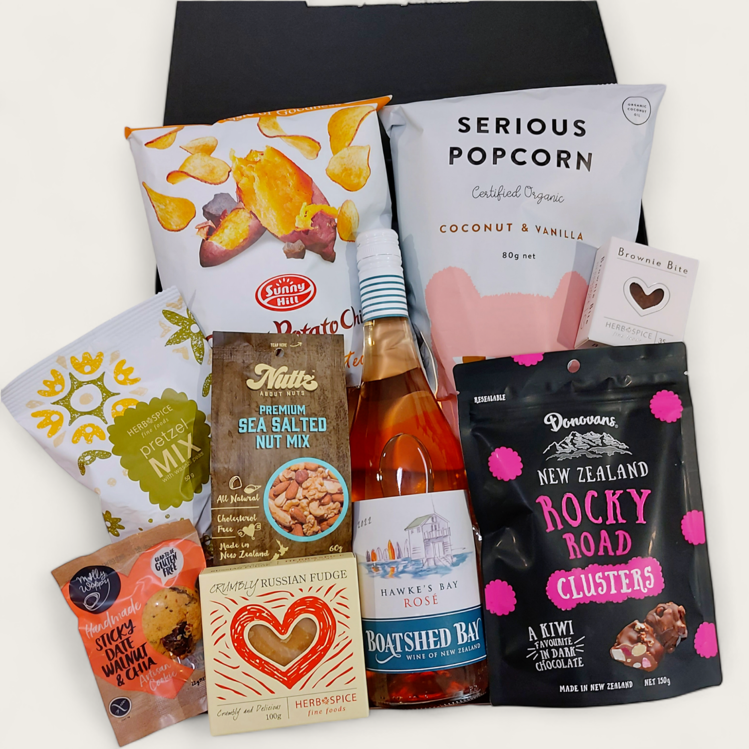 Cheers gift hamper with wine, popcorn, chocolate, fudge, brownie & nuts presented in a beautiful Gift Box.