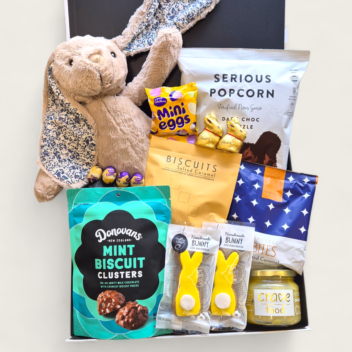 Easter gift hamper with bunny toy, chocolates, popcorn and sweet treats