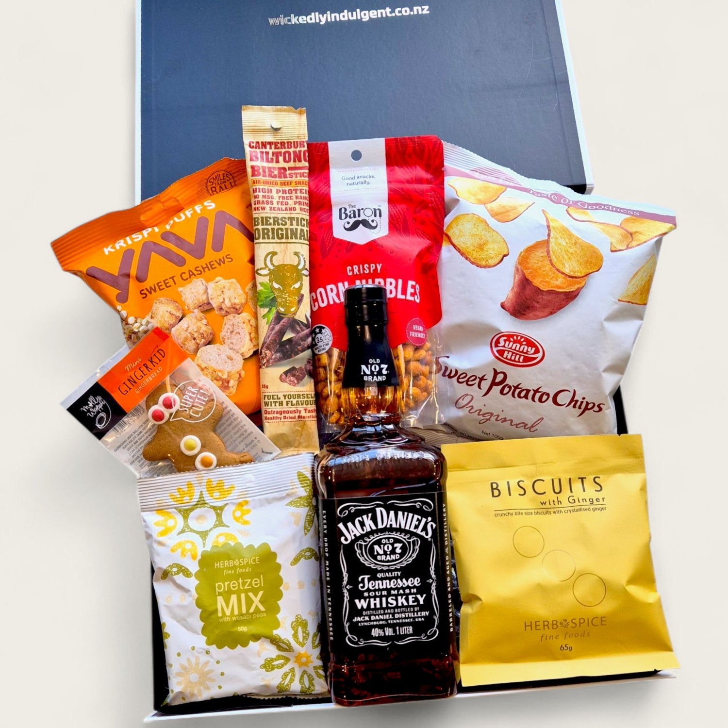 Gift box featuring Jack Daniel’s whiskey, gourmet snacks, corn nibbles, popcorn, and biscuits arranged in a black gift box – perfect for Father’s Day or gifting him.