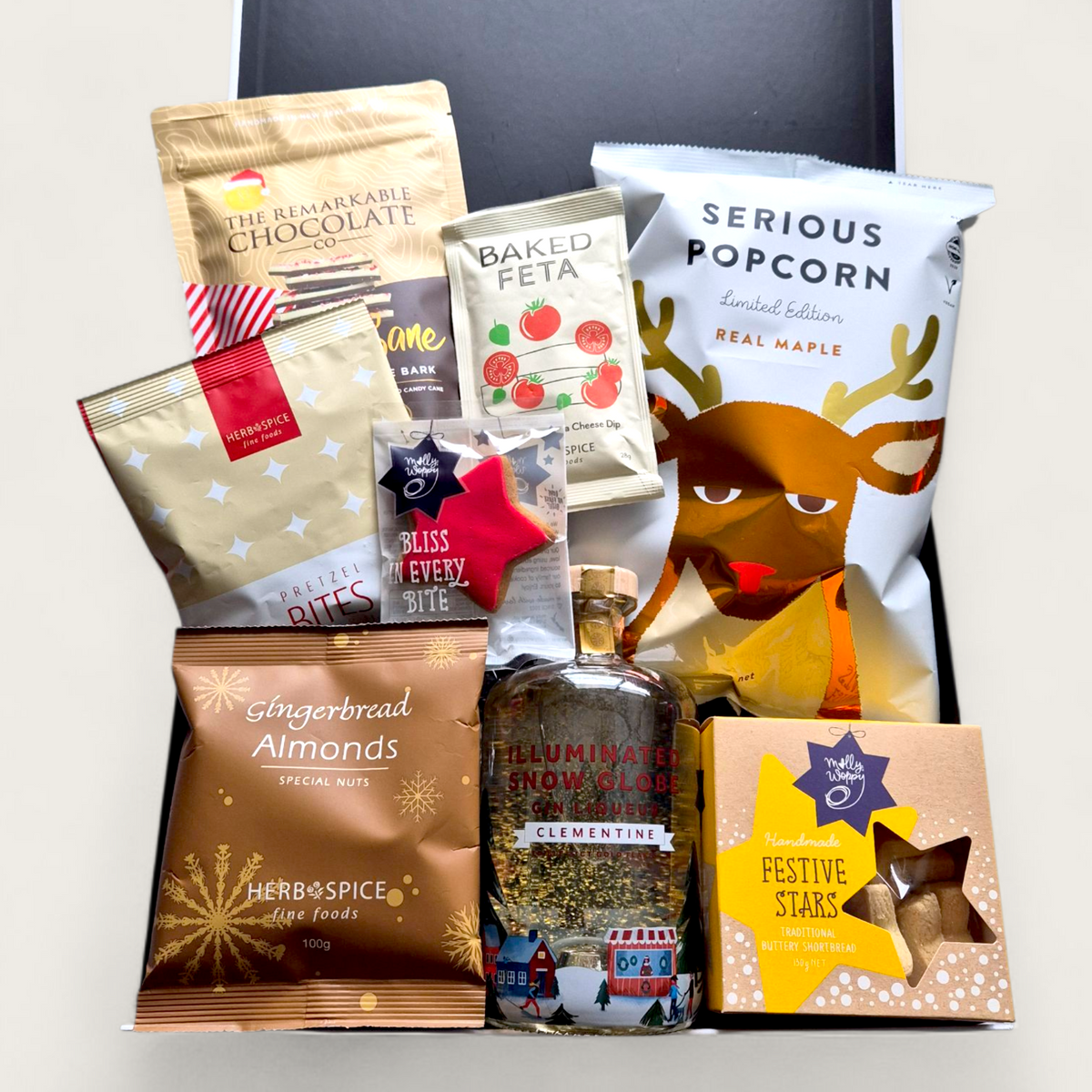 Let It Glow Snow Globe Gin Gift Box with LED-lit Clementine gin bottle, gold flakes, and artisan snacks in a festive black gift box.