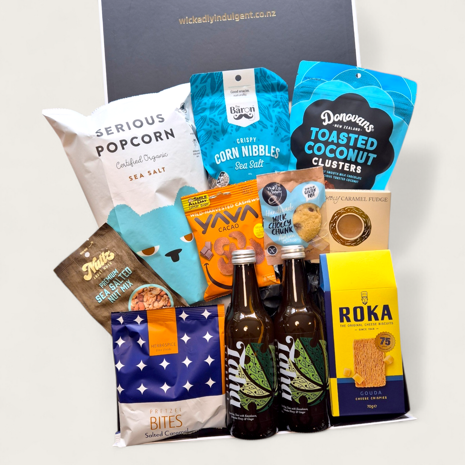 Taha gift basket with Taha soft drink, chocolate, cheesy bites, nuts & popcorn, all presented in a beautiful modern gift box.