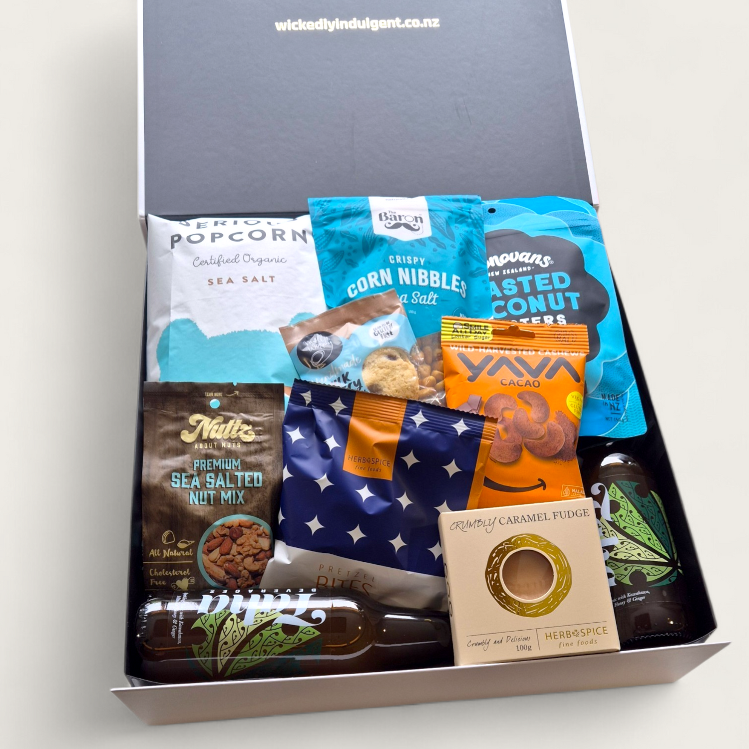 Taha gift basket with Taha soft drink, chocolate, cheesy bites, nuts & popcorn, all presented in a beautiful modern gift box.