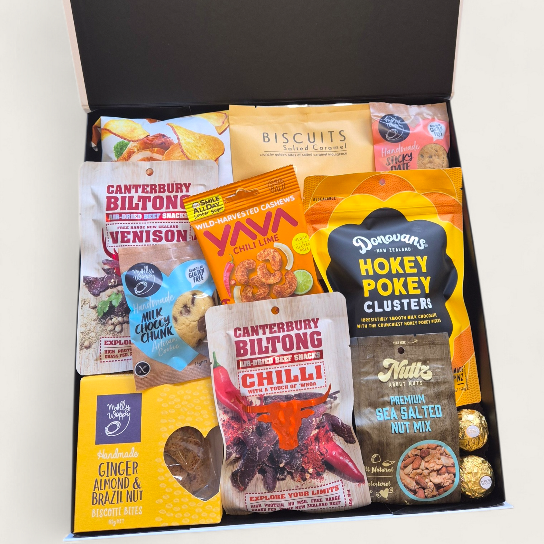 Non alcoholic gift hamper with an assortment of sweet and savoury snacks. Presented in a modern gift box.