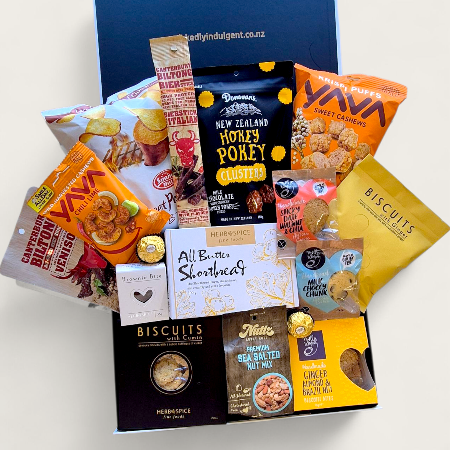 Non alcoholic gift hamper with an assortment of sweet and savoury snacks. Presented in a modern gift box.