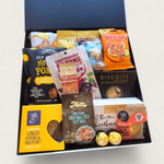 Non alcoholic gift hamper with an assortment of sweet and savoury snacks. Presented in a modern gift box.