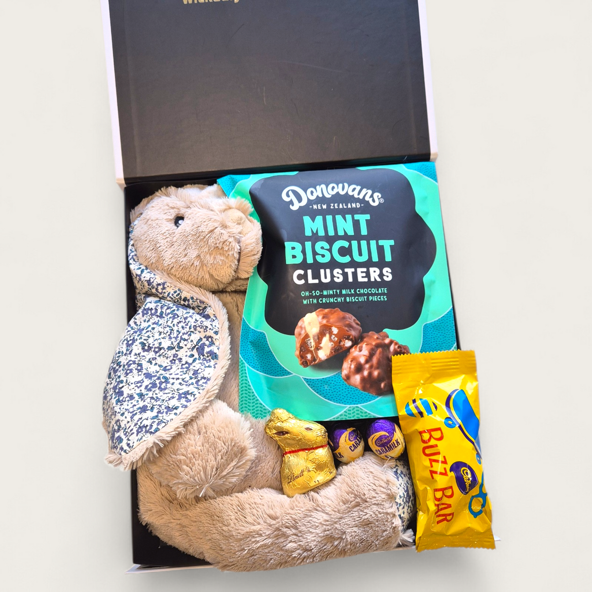 Easter gift box with plush bunny toy, mint biscuit clusters, Cadbury eggs and chocolate treats
