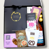 Gift hamper with wine, chocolate, candle, handcream, bodywash and shortbread. The perfect gift for her.