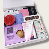 A sprinkle of pink gift hamper with hand cream, cleansing bar, tea and afternoon tea treats all presented in a modern gift box.