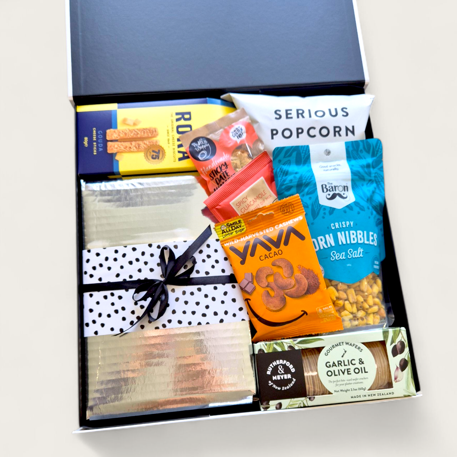 Craving crusher gift basket with cheese, pickles, chocolate, popcorn, cookie and more all presented in a modern gift box.