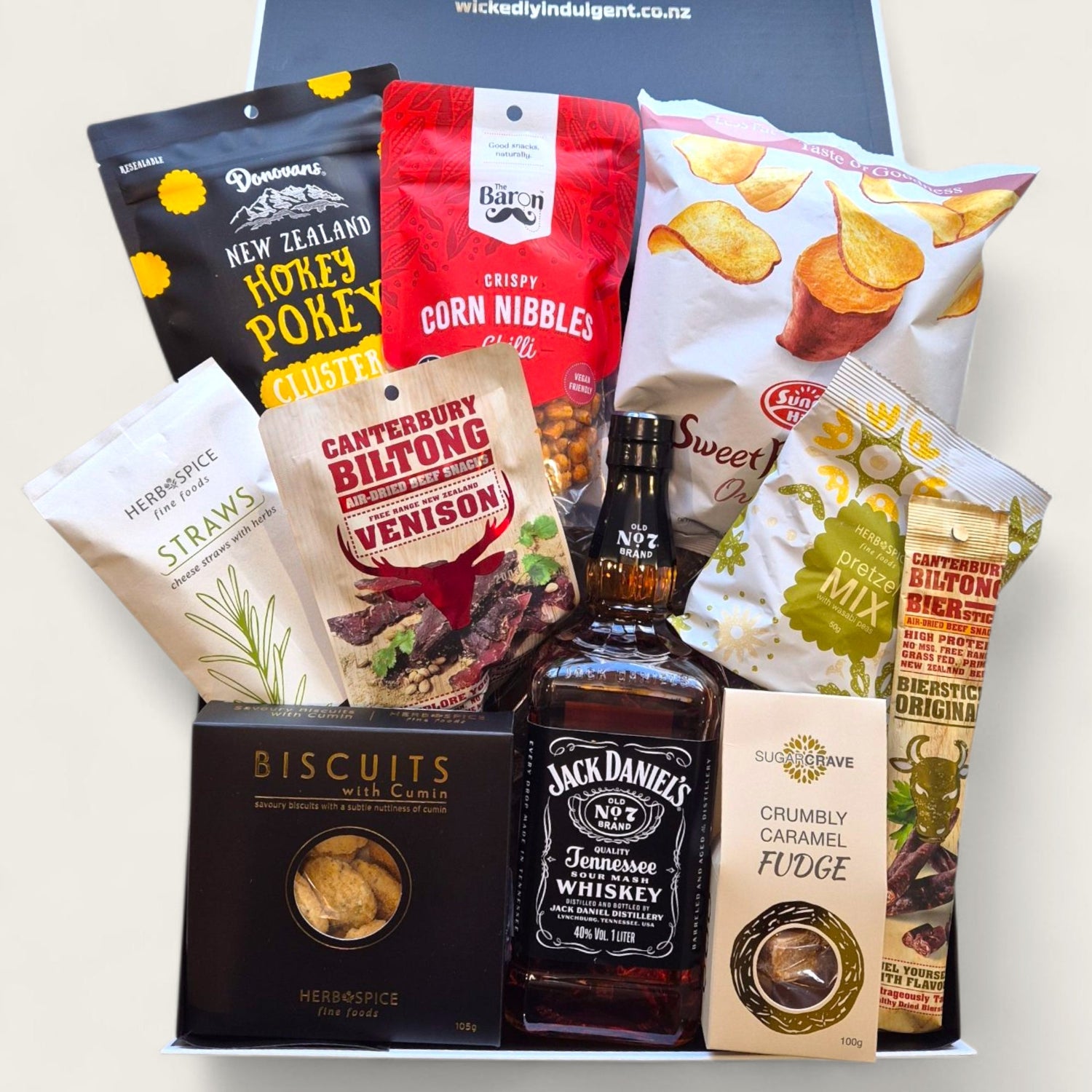 Jack in the Box gift hamper with Jack Daniels whiskey, artisan New Zealand snacks, gourmet biscuits, crisps, and sweet treats in a sleek Wickedly Indulgent gift box.