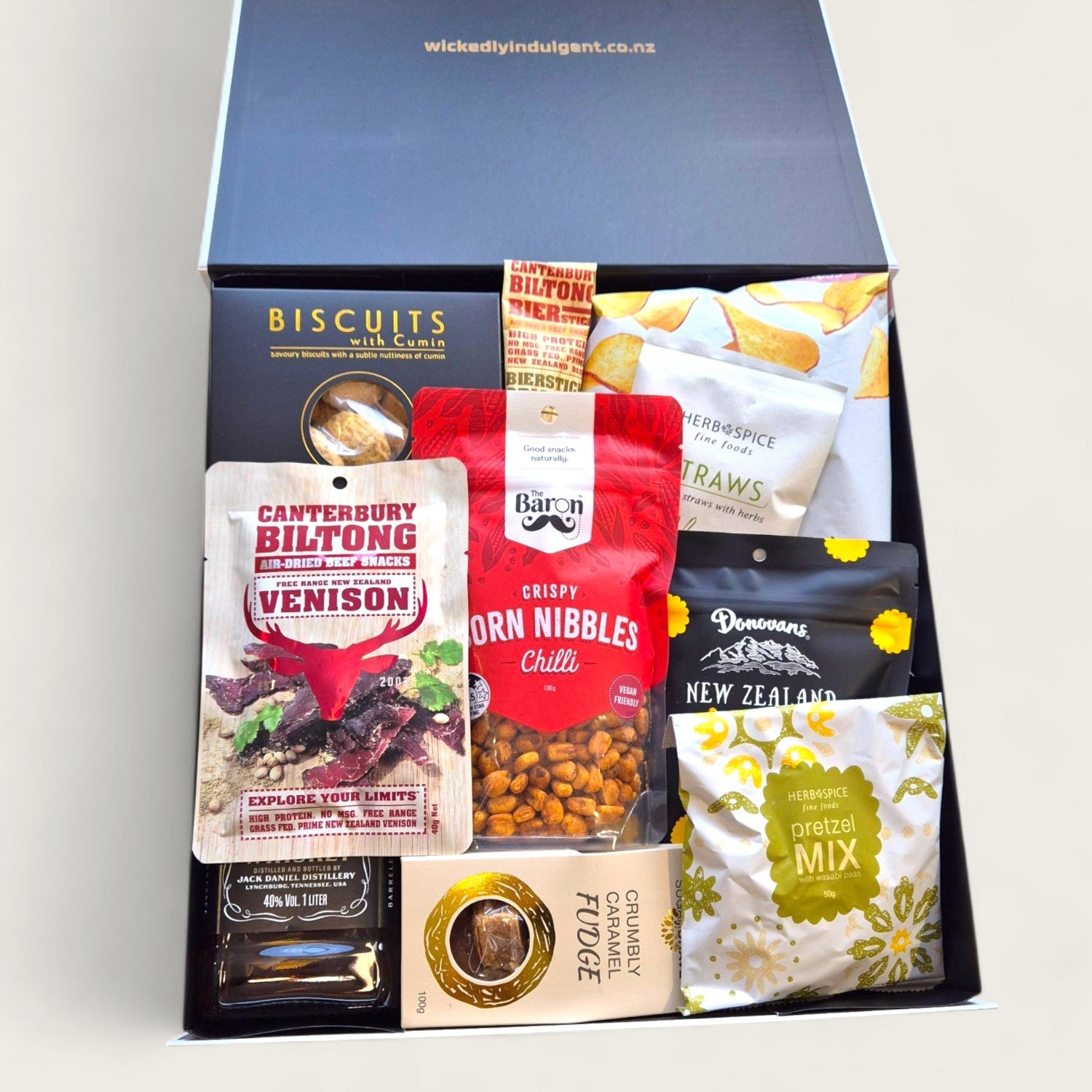Jack in the Box gift hamper with Jack Daniels whiskey, artisan New Zealand snacks, gourmet biscuits, crisps, and sweet treats in a sleek Wickedly Indulgent gift box.