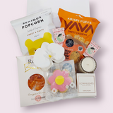 Little luxuries gift box with candle, flower and sweet treats. Presented in a modern gift box.