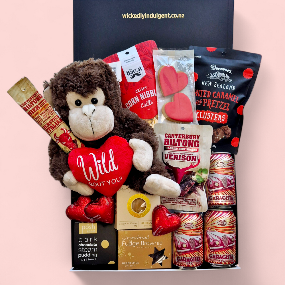 Love Gone Wild Gift Box featuring a 'Wild About You' monkey teddy, beer or wine, venison biltong, chocolate, gingerbread hearts, fudge, and a steam pudding. A playful & fun Valentine’s Day hamper.