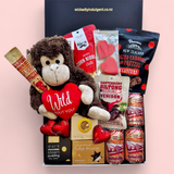 Love Gone Wild Gift Box featuring a 'Wild About You' monkey teddy, beer or wine, venison biltong, chocolate, gingerbread hearts, fudge, and a steam pudding. A playful & fun Valentine’s Day hamper.