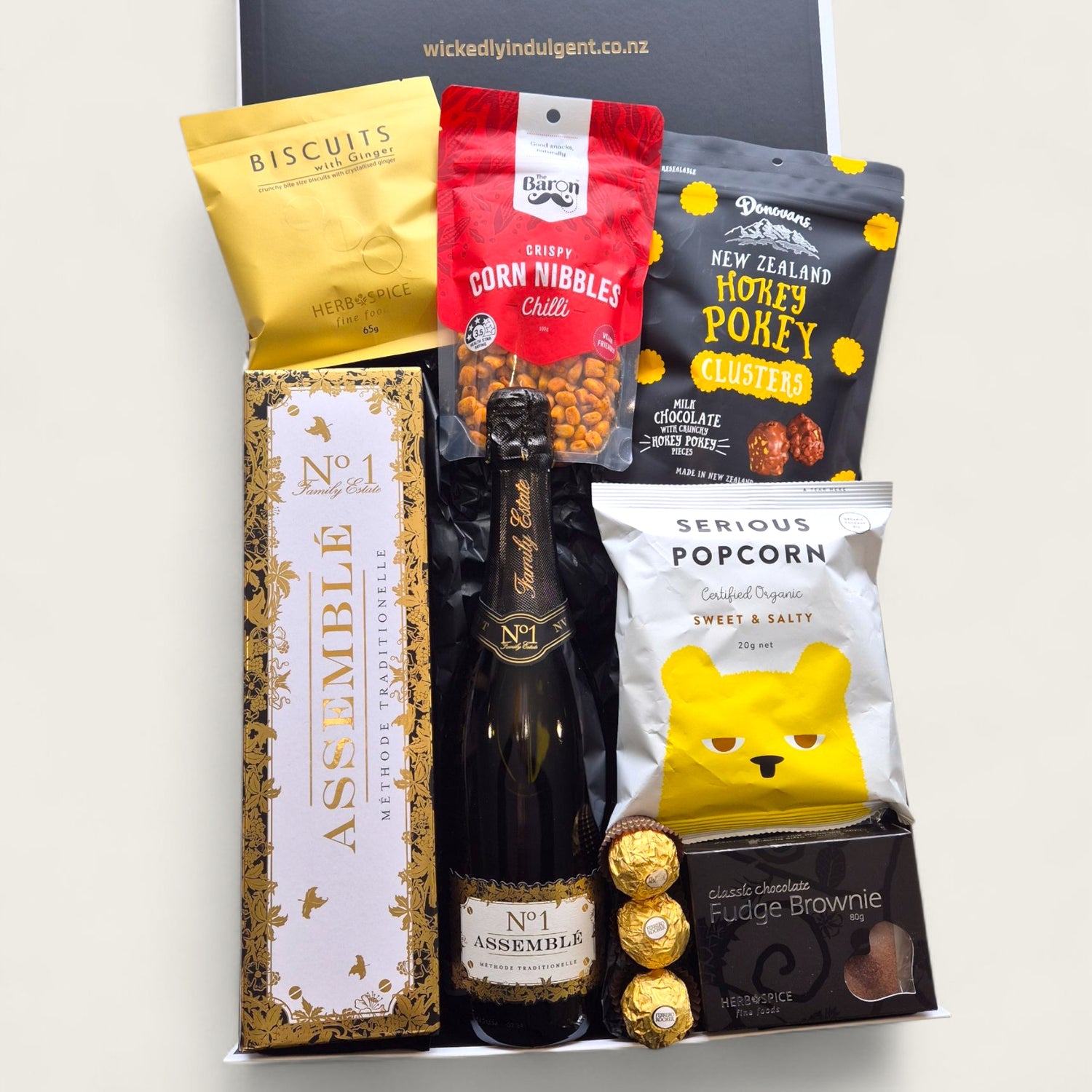 Champagne gift hamper with Assemble Brut, biscuits, popcorn, chocolate, and Ferrero Rocher in black and white box