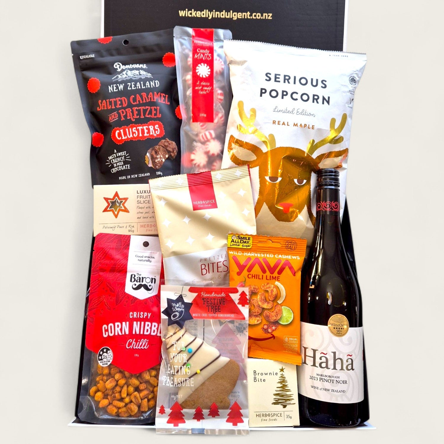 Christmas gift hamper “Sip, Snack & Sleigh” with NZ wine, gourmet popcorn, chilli cashews, pretzel bites, and festive sweets.