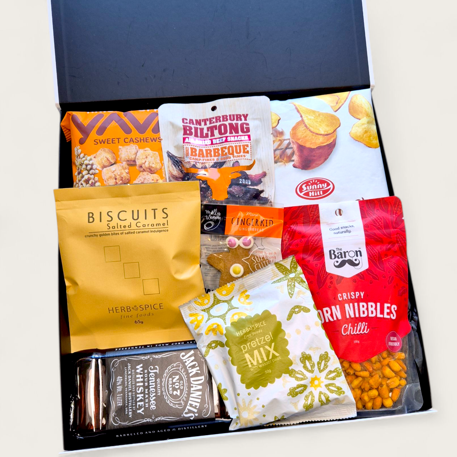 Gift box featuring Jack Daniel’s whiskey, gourmet snacks, corn nibbles, popcorn, and biscuits arranged in a black gift box – perfect for Father’s Day or gifting him.