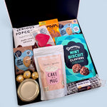 Sweet treat gift hamper with lemon passionfruit curd, cookies, cake in a mug, chocolate and more presented in a modern gift box.
