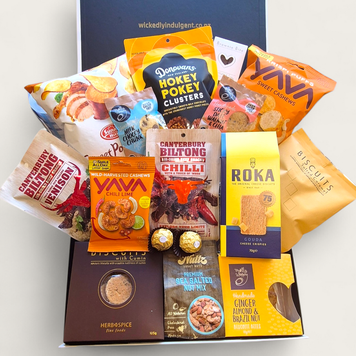 Non alcoholic gift hamper with an assortment of sweet and savoury snacks. Presented in a modern gift box.