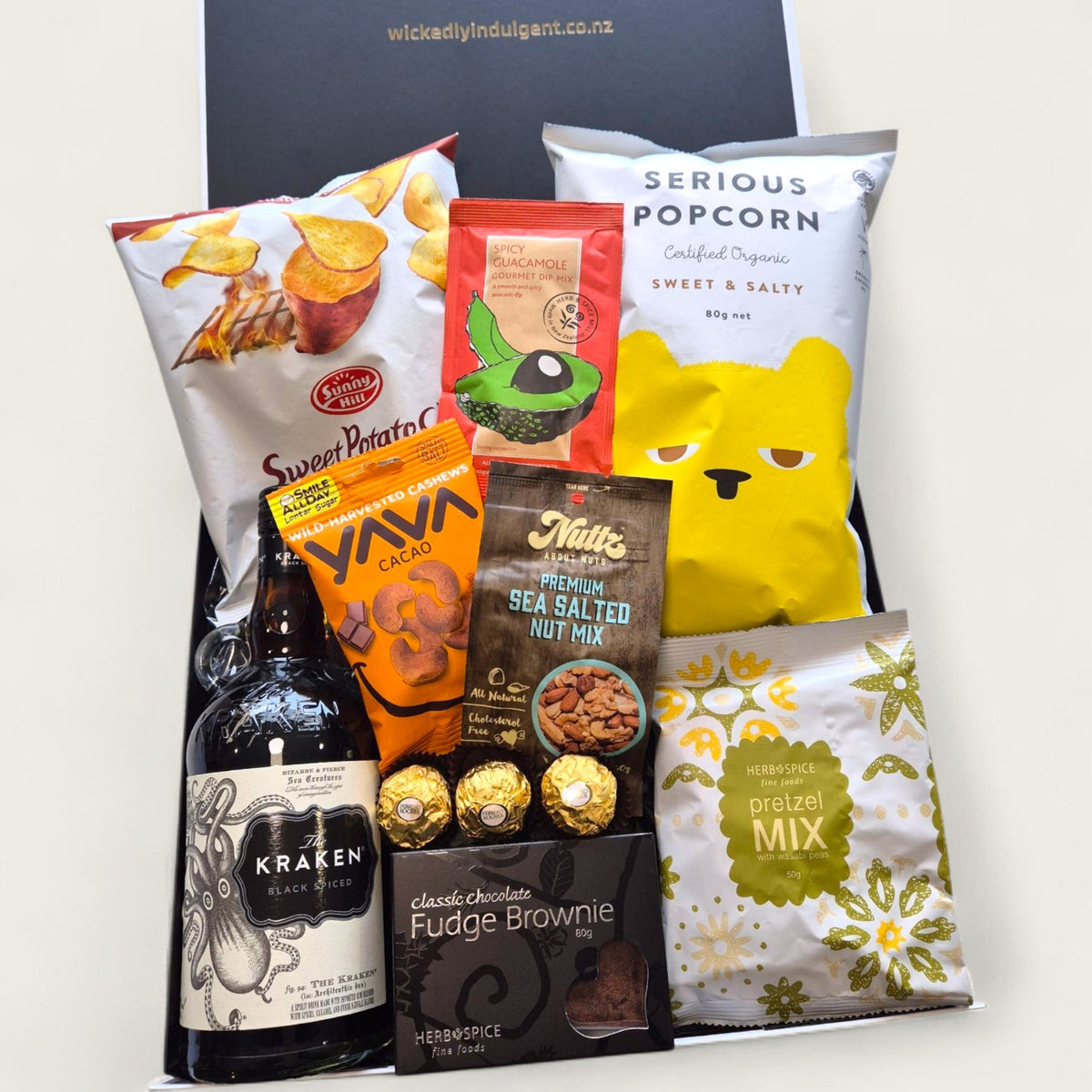 Kraken rum gift hamper with kumara chips, brownie, nuts, Ferrero Rocher, and gourmet snacks in black and white gift box