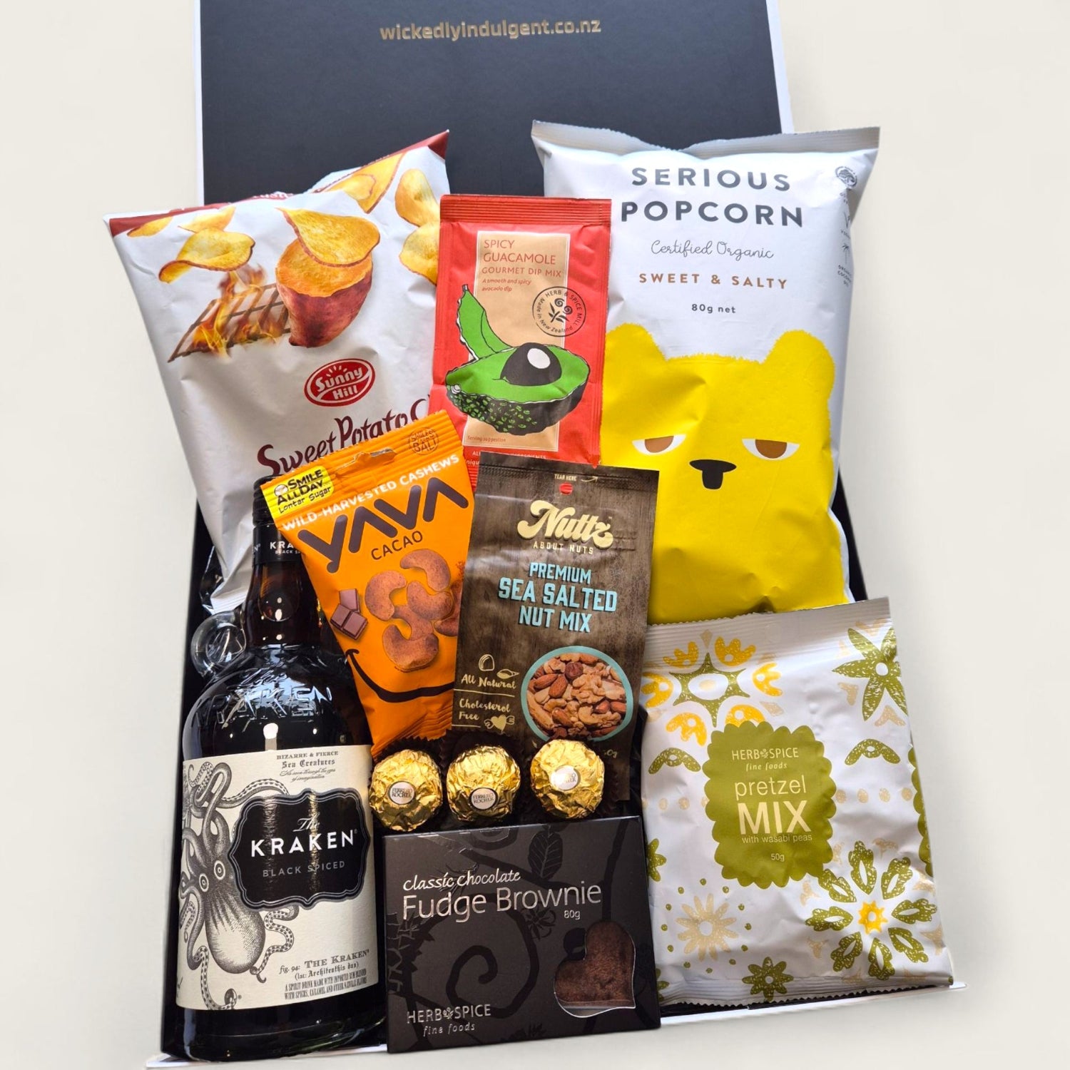 Kraken rum gift hamper with kumara chips, brownie, nuts, Ferrero Rocher, and gourmet snacks in black and white gift box