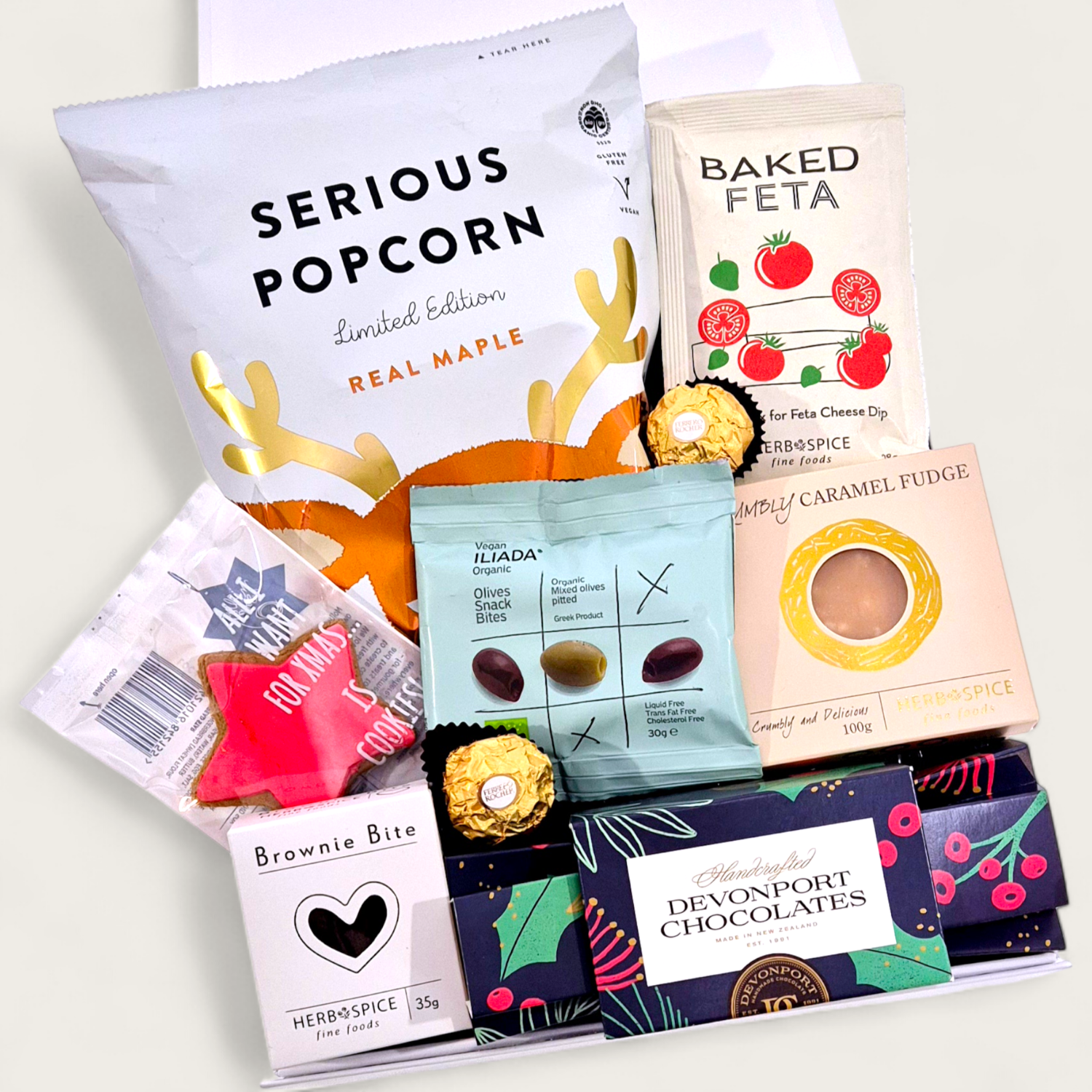 Christmas Cracker festive gift box with gourmet treats, chocolate cracker, fudge, popcorn and Christmas snacks arranged in white gift box.