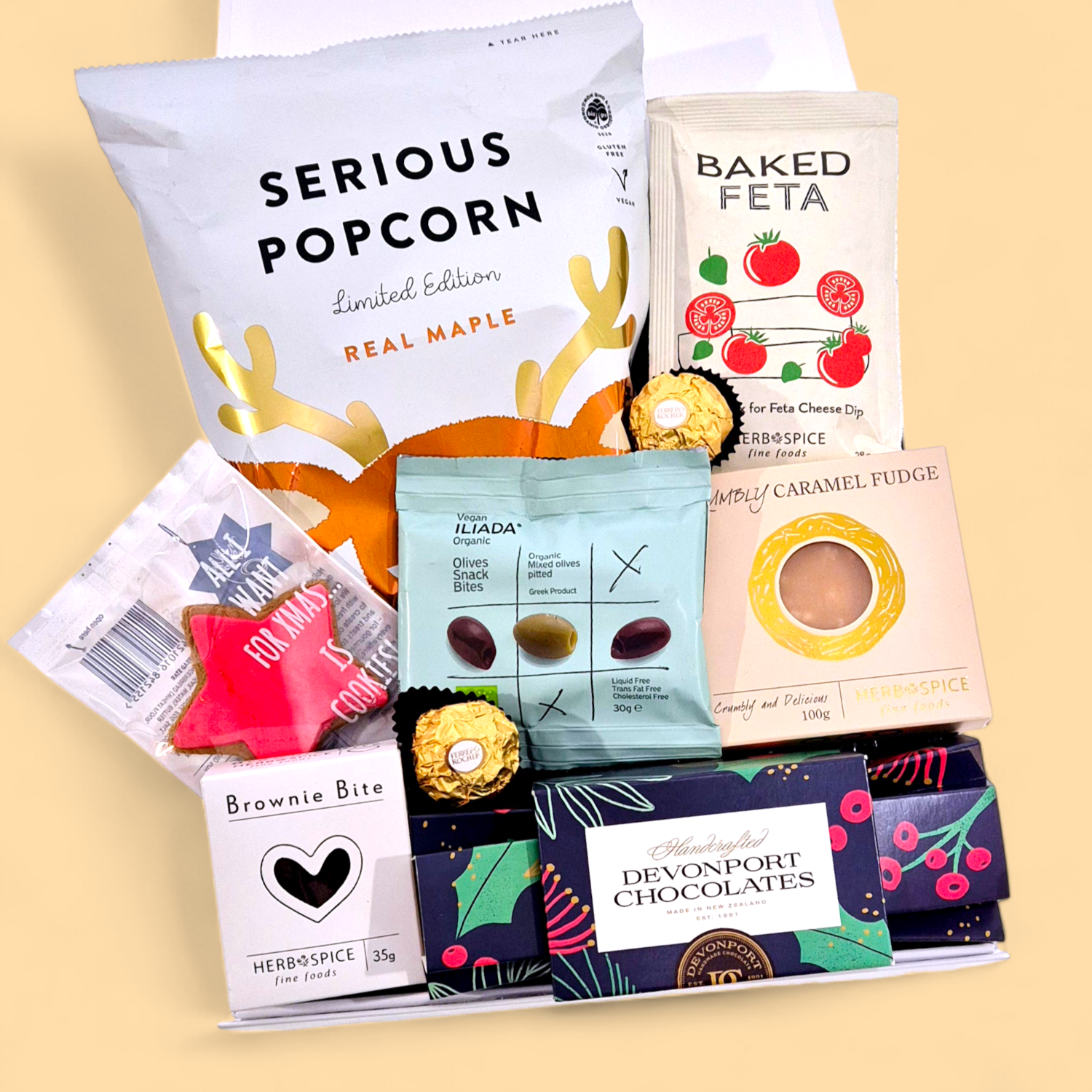 Christmas Cracker festive gift box with gourmet treats, chocolate cracker, fudge, popcorn and Christmas snacks arranged in white gift box.