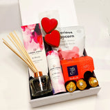 In Bloom gift basket with room diffuser, bath bombs, gingerbread, cookies and popcorn all presented in a modern gift box.