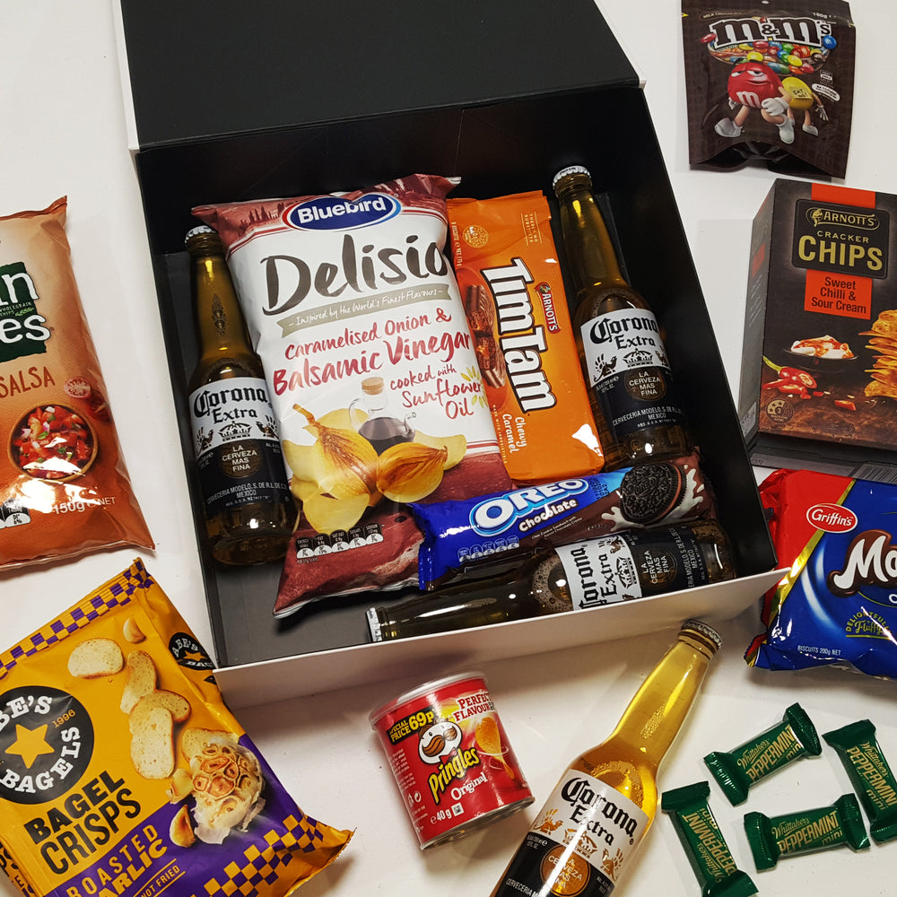 Brews & Bites Gift Basket with Grain Waves, Bagel Crisps, Whittakers, Tim Tams, Corona & more all presented in a modern gift basket.