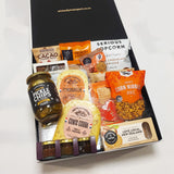 Craving crusher gift basket with cheese, pickles, chocolate, popcorn, cookie and more all presented in a modern gift box.
